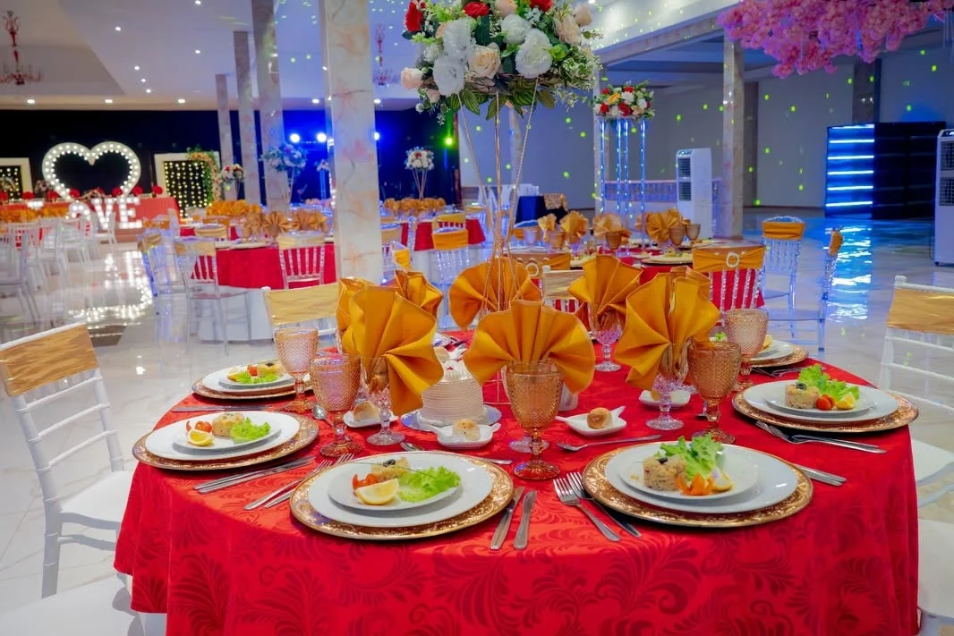 Mesa redonda preparada con vajilla, cristalería y decoración para celebración