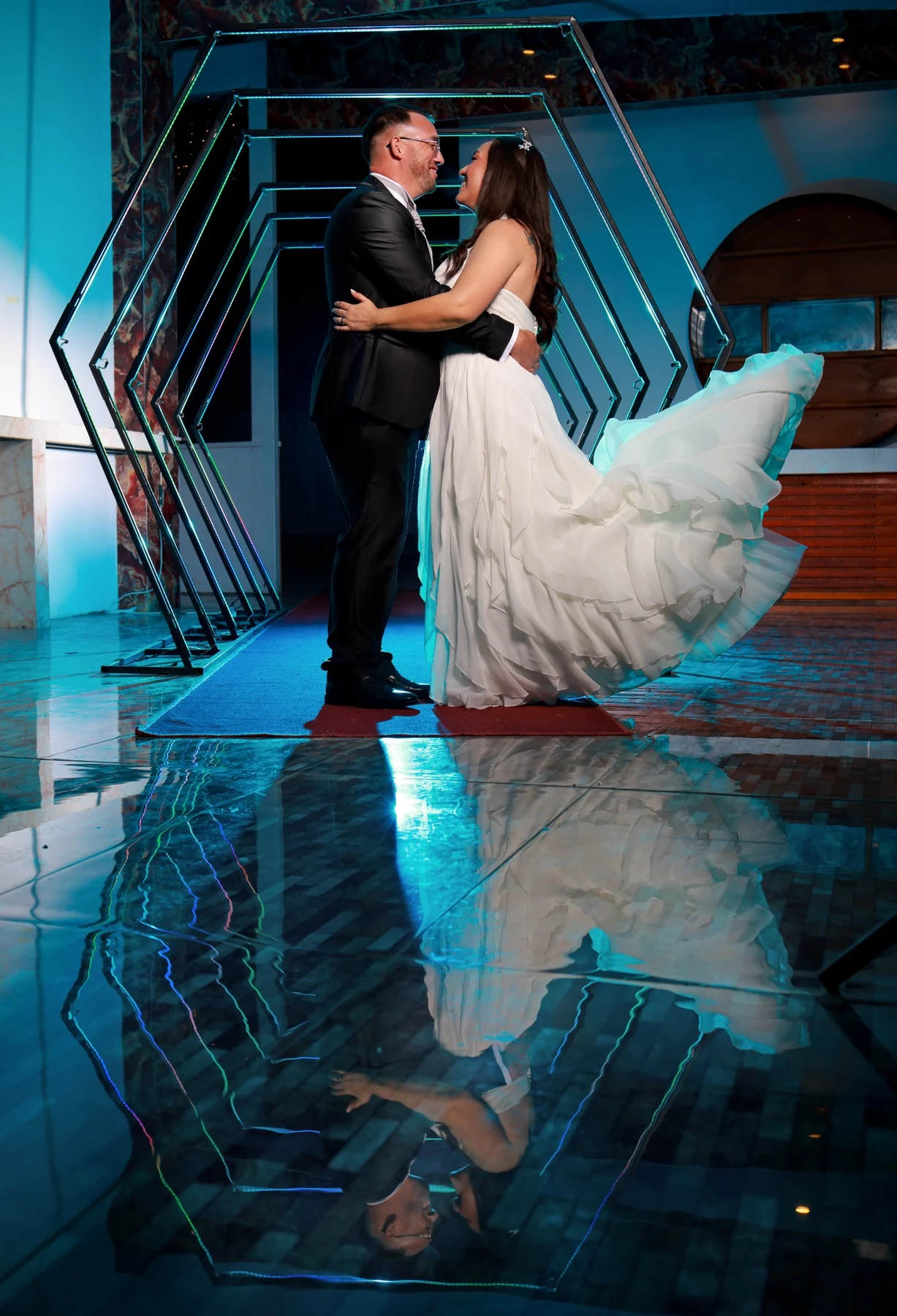 Pareja de novios en acceso escénico iluminado